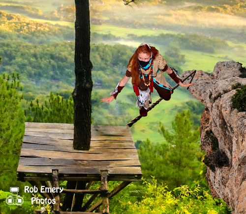 Aloy, crossing a rope bridge over the zero dawn lands
